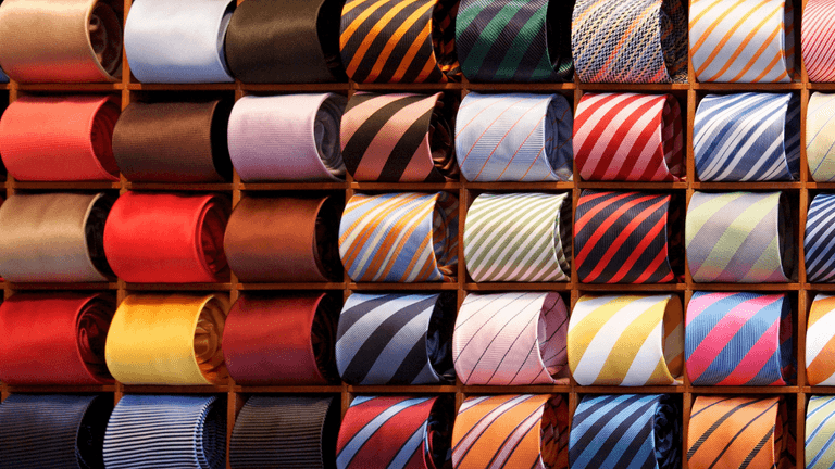 A colorful display of neatly arranged ties in a wooden wall rack